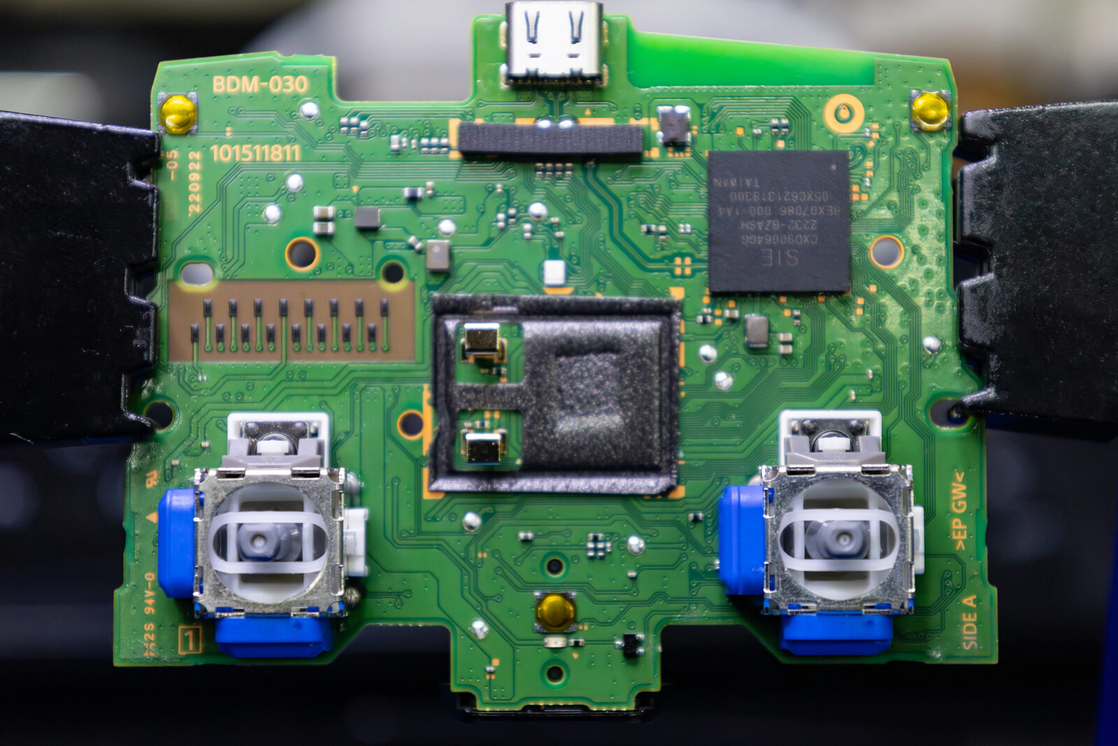 A PS5 DualSense circuit board with replacement joystick modules soldered in position