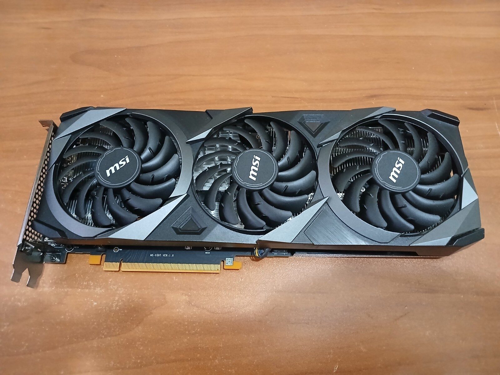 An MSI RTX 3060 12GB Ventus graphics card with three fans, lying on a desk